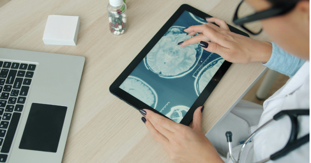Doctor reviewing brain scan on a tablet using artificial intelligence in healthcare for accurate diagnosis and patient care.